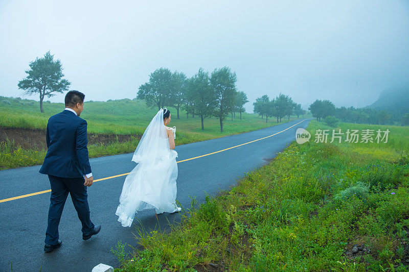 一对新婚夫妇走在乡间小路上
