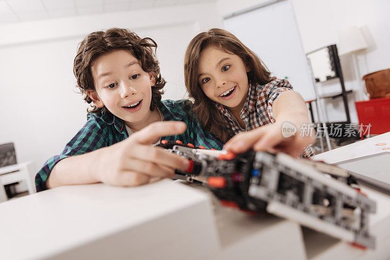 快乐的孩子们在工作室里编写电子机器人