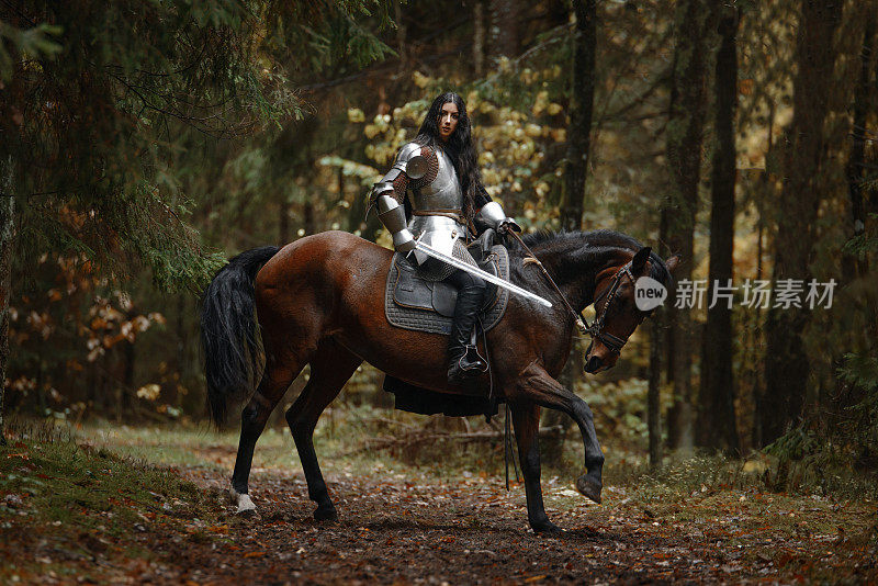 一个美丽的战士女孩带着剑，穿着链甲和盔甲骑在一匹马在一个神秘的森林。