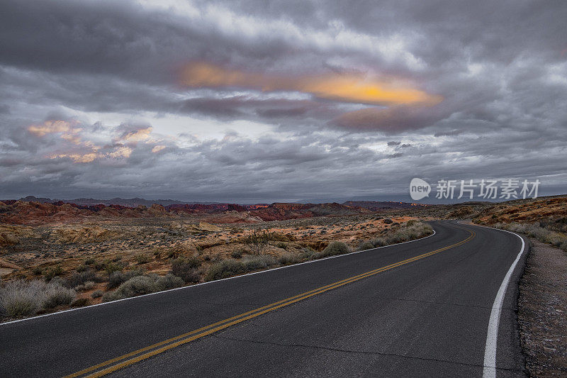 戏剧性的日出在沙漠景观与空的道路