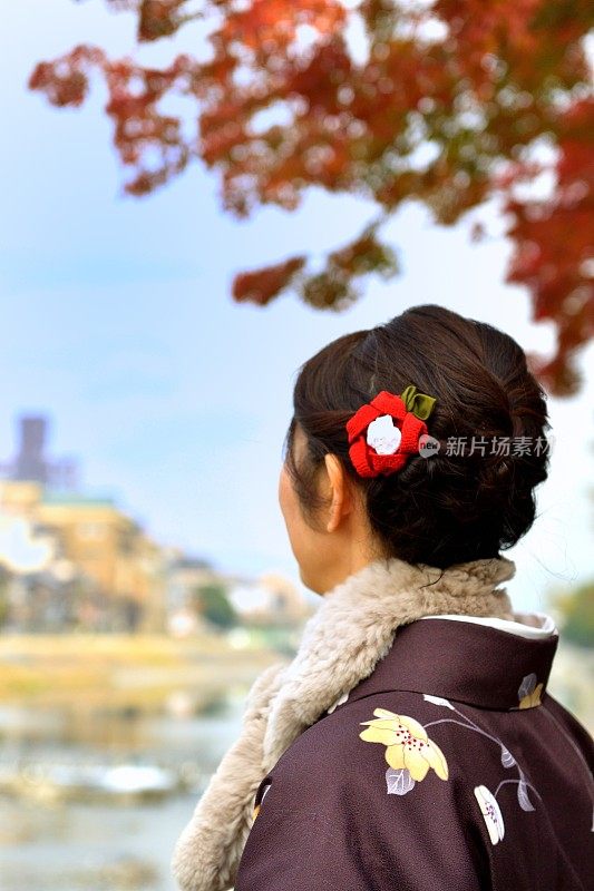 穿着和服的日本妇女在京都的秋天沿着加茂河行走