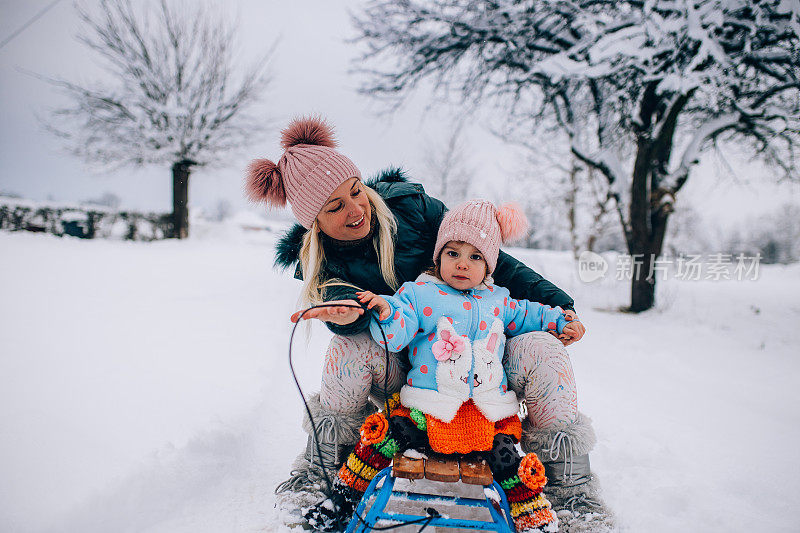 妈妈和宝宝享受雪橇之旅