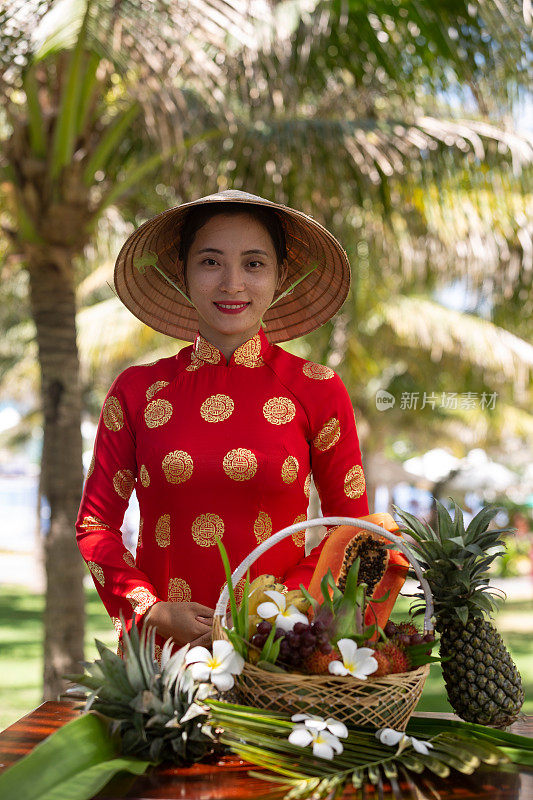 异国传统越南女孩与各种热带水果篮子