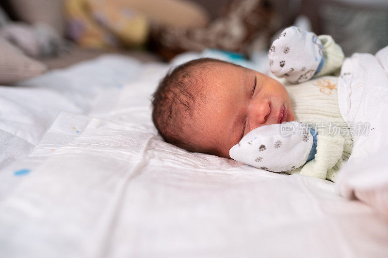 新生儿戴着棉手套睡觉