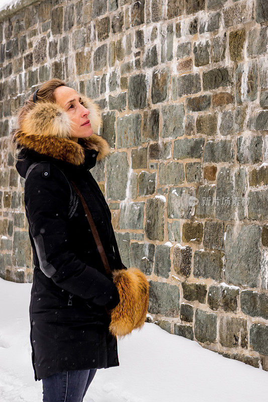 女人看着老魁北克城周围的墙。