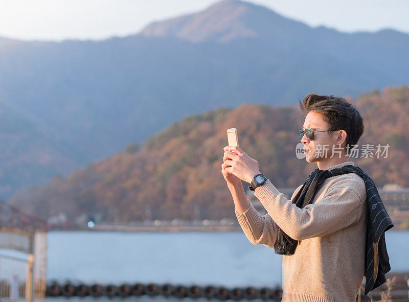 年轻的亚洲男子和日本朋友寻找旅游地点使用手机和花时间在亚洲旅行