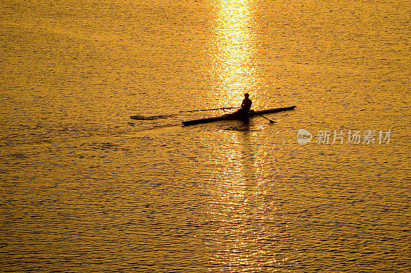 在清晨的阳光下，一艘小船沿着波光粼粼的尤多河航行