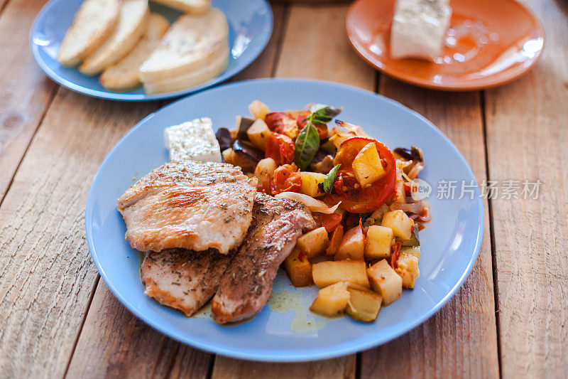 希腊炖菜，烤蔬菜，配猪排和羊乳酪