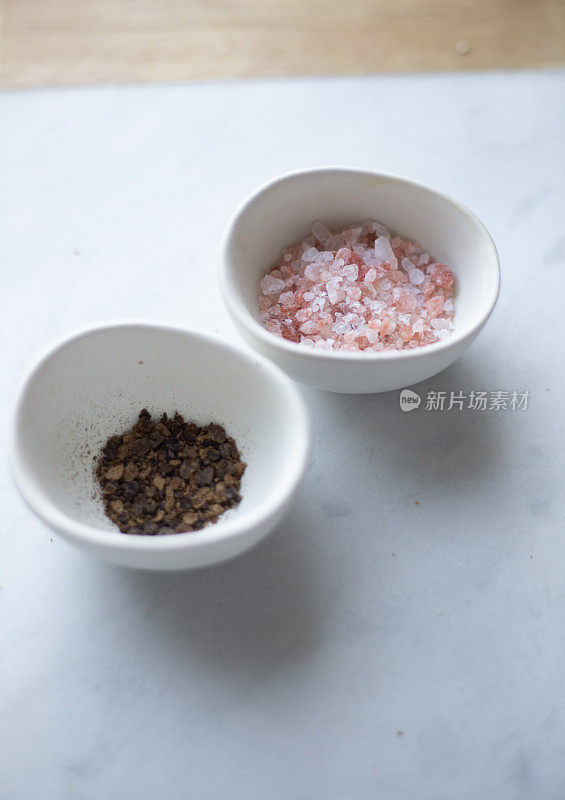 大理石背景上的喜马拉雅盐和胡椒