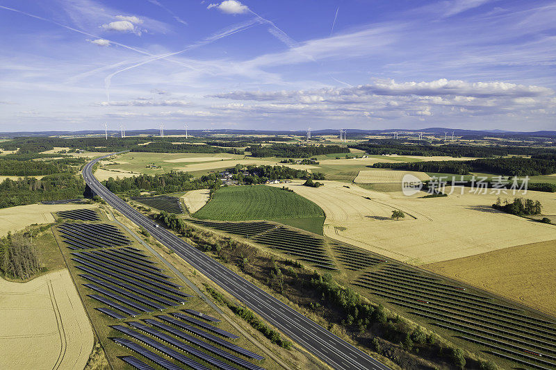 高速公路附近现代太阳能电池板和风力涡轮机的鸟瞰图