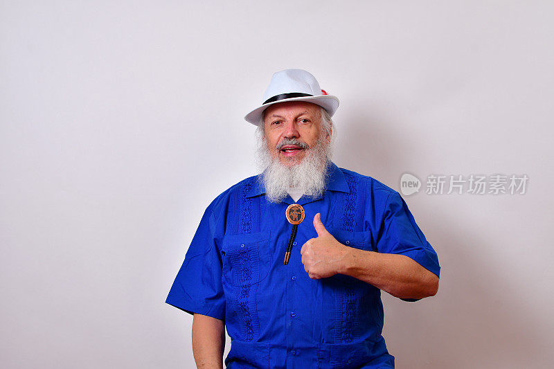 快乐的微笑老人，白色软呢帽，蓝色瓜亚贝拉衬衫，和波洛领带显示大拇指