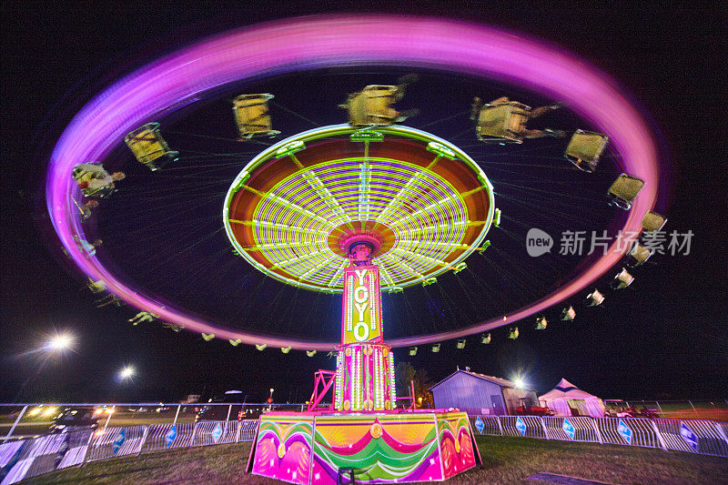 在集市或狂欢节上，戴着紫色环的溜溜球旋转木马