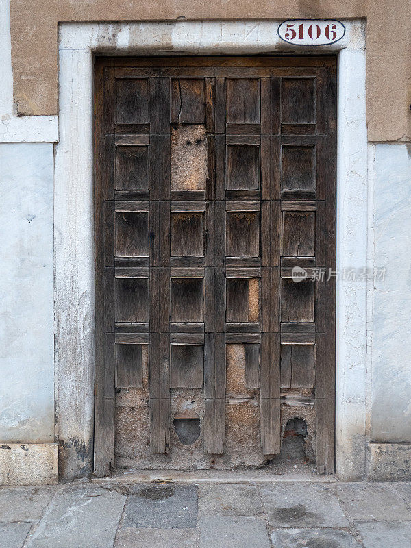 威尼斯老建筑上风化的木制前门