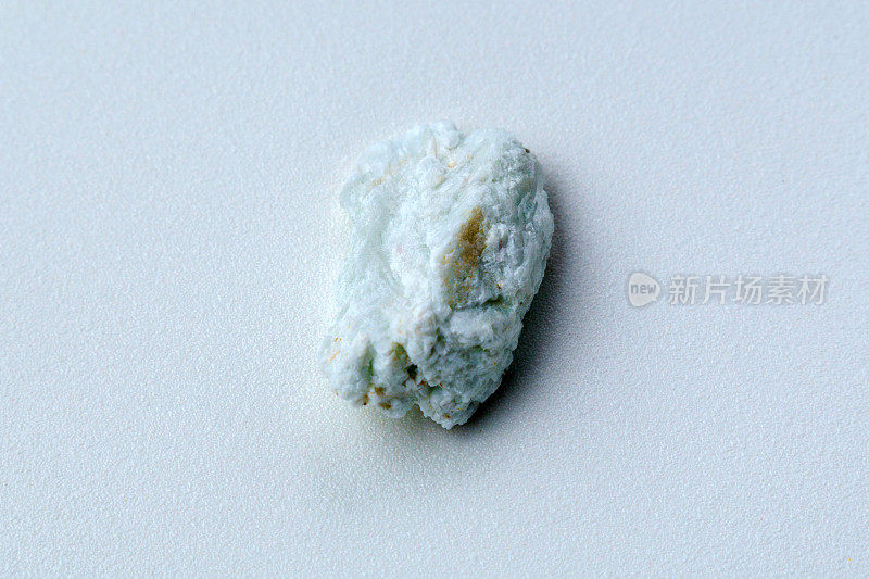 宏观石钠长石矿物白色背景特写。海蓝宝石在钠长岩