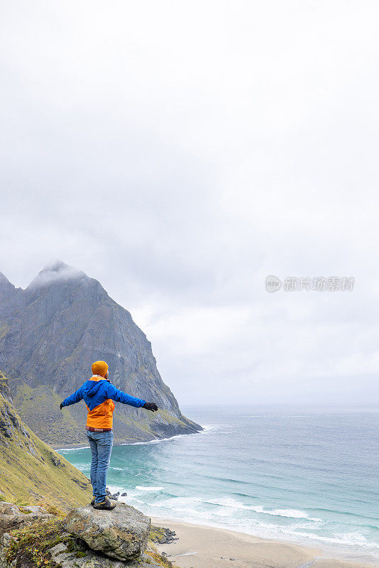 快乐的徒步旅行者站着，双臂张开，只为自己拥抱大自然