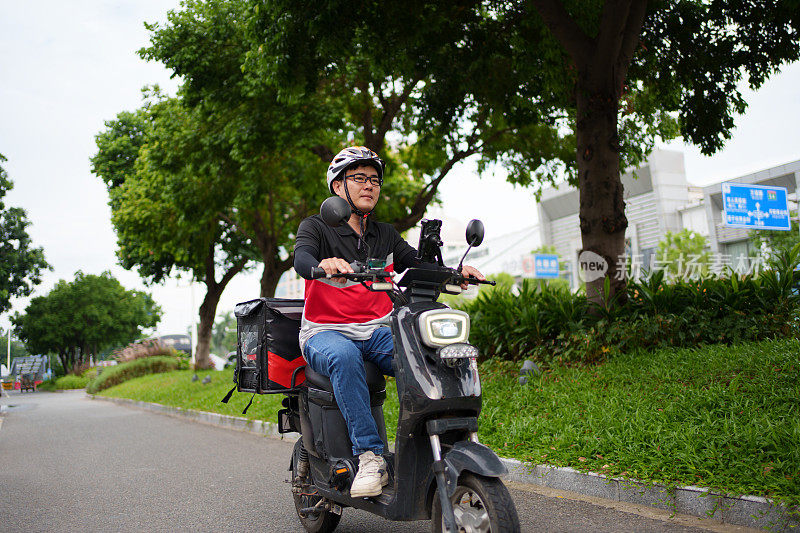 送餐员骑着电动自行车