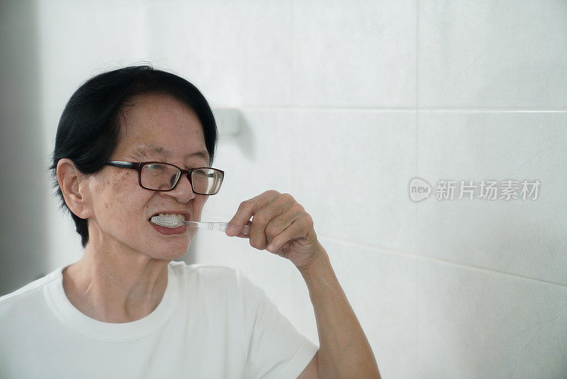 亚洲老年妇女早上第一件事就是刷牙。