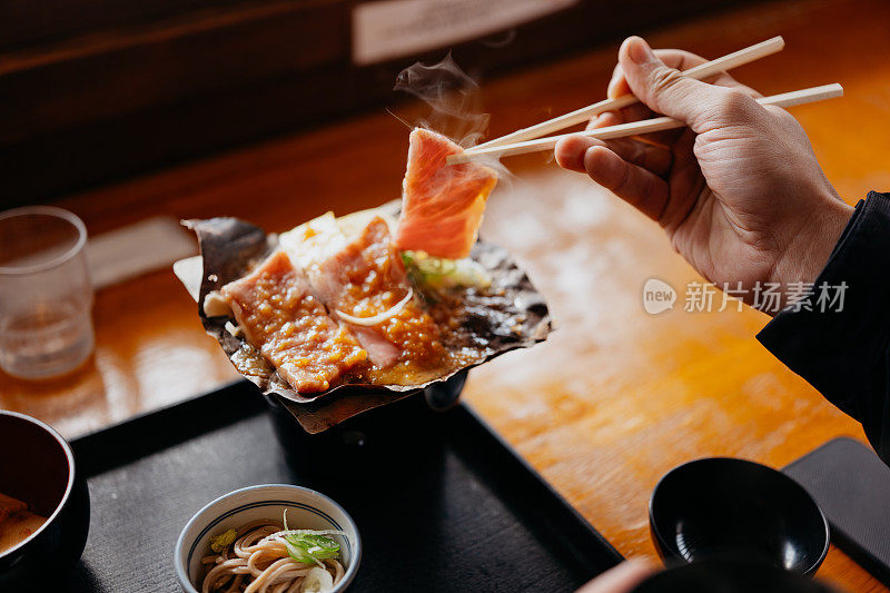 一名男子在餐厅里吃着飞田牛肉河豚味噌