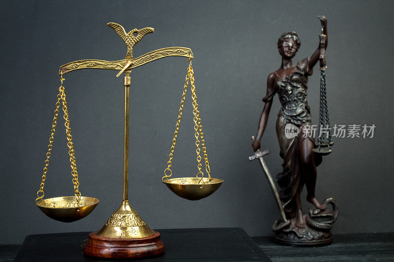 夫人正义。正义雕像，木质背景上的鳞片。法律和法律概念。