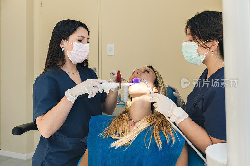 牙医及助手使用牙科紫外线光