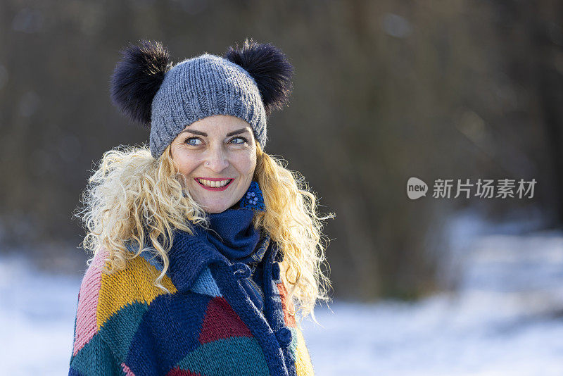 幸福的女人在冬天森林附近的白雪皑皑的草地