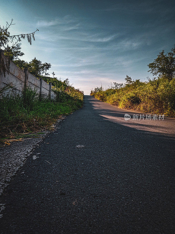 背景是一条上坡的柏油路