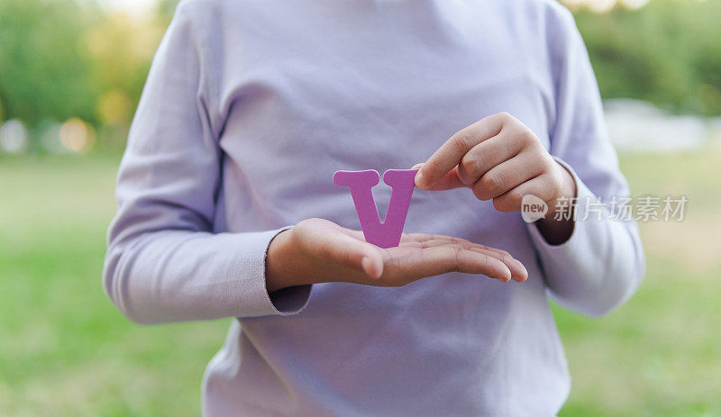 小孩拿着字母“V”