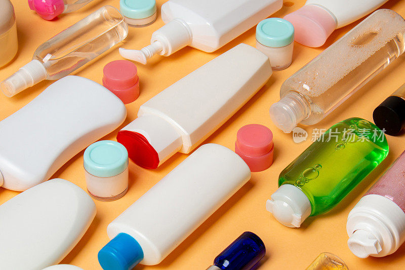 一组塑料护身瓶，用彩妆品平铺构图，在彩色背景上留白供您设计。一套白色化妆品容器，顶部视图与复制空间