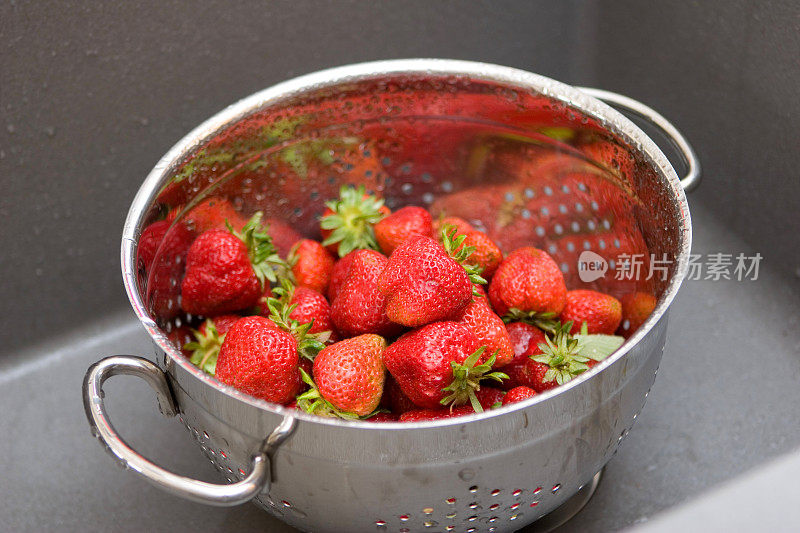 洗过的草莓和金属滤器在水槽