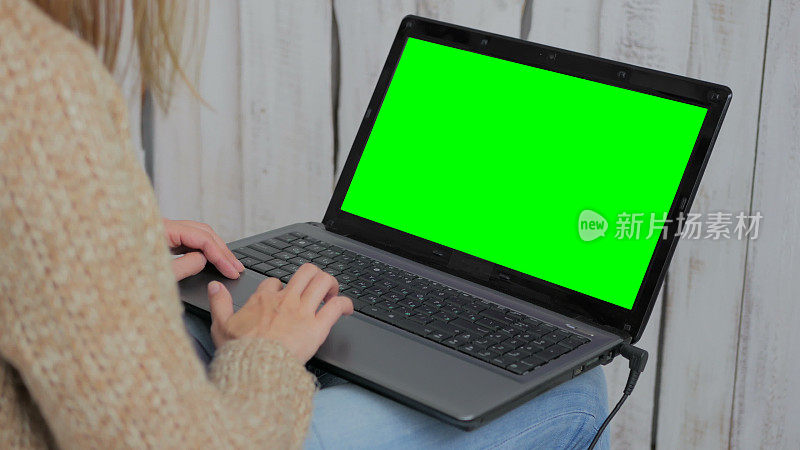 用绿屏笔记本电脑的女人