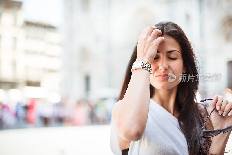 一个女人在街上摸她的头发