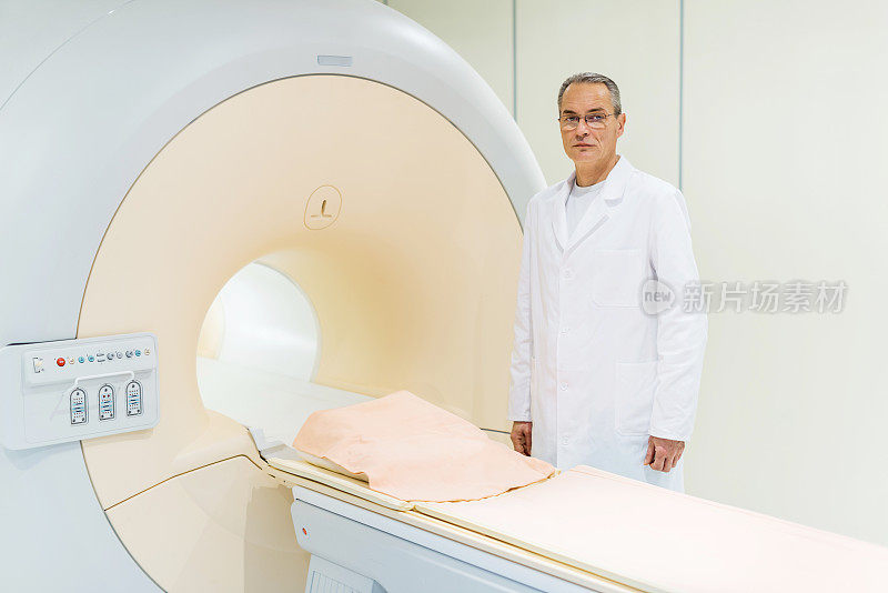 成熟的男性医生和MRI扫描仪。