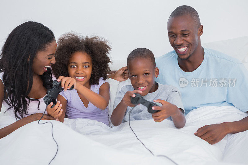 一家人在床上玩电子游戏