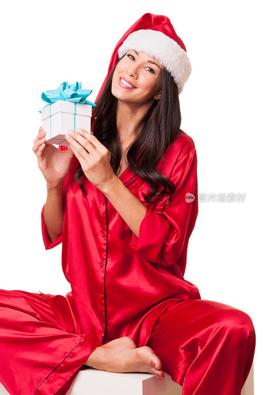 年轻女子穿着红色睡衣，戴着圣诞帽和礼物