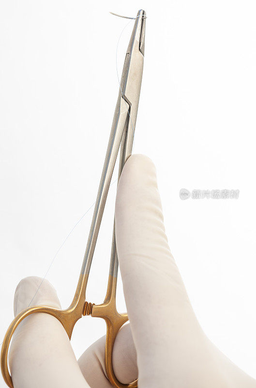 外科医生使用带针和带缝线的针夹