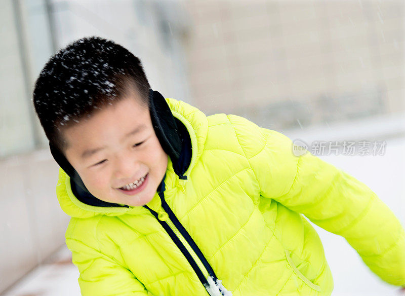 一个亚洲男孩在雪地里玩