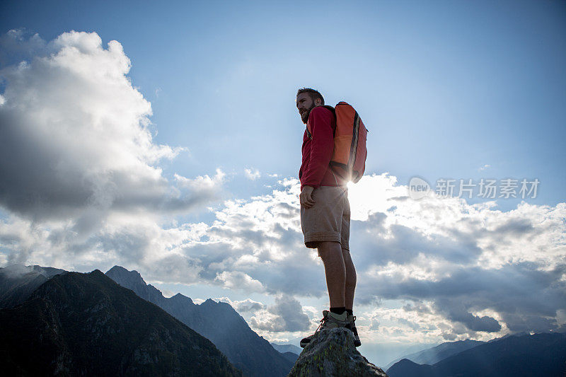 一个年轻的徒步旅行者站在山顶上