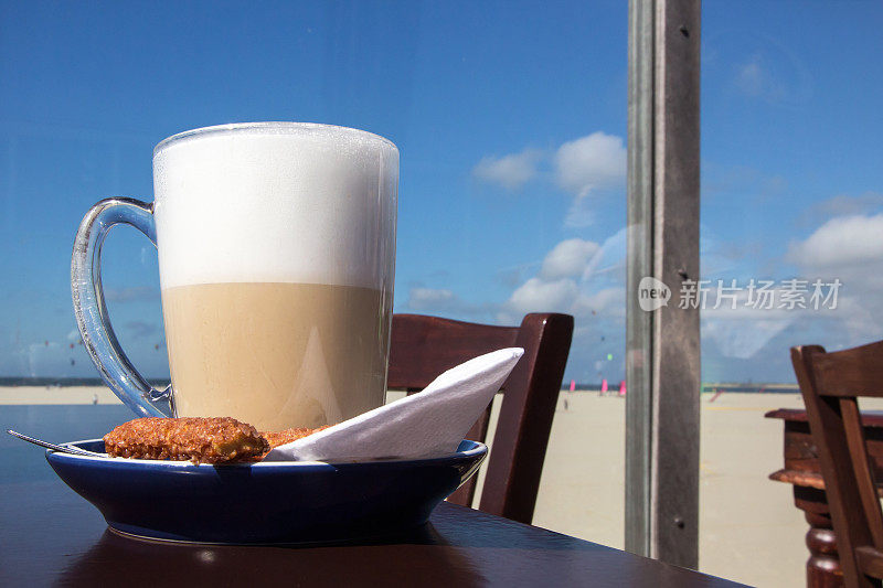 在海滩上，一大杯拿铁咖啡