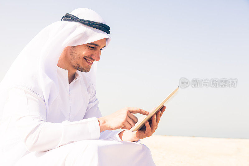 坐在海滩上的阿拉伯青年