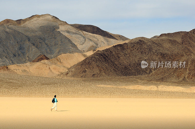 行走在美国死亡谷棉木山附近沙漠中的女人