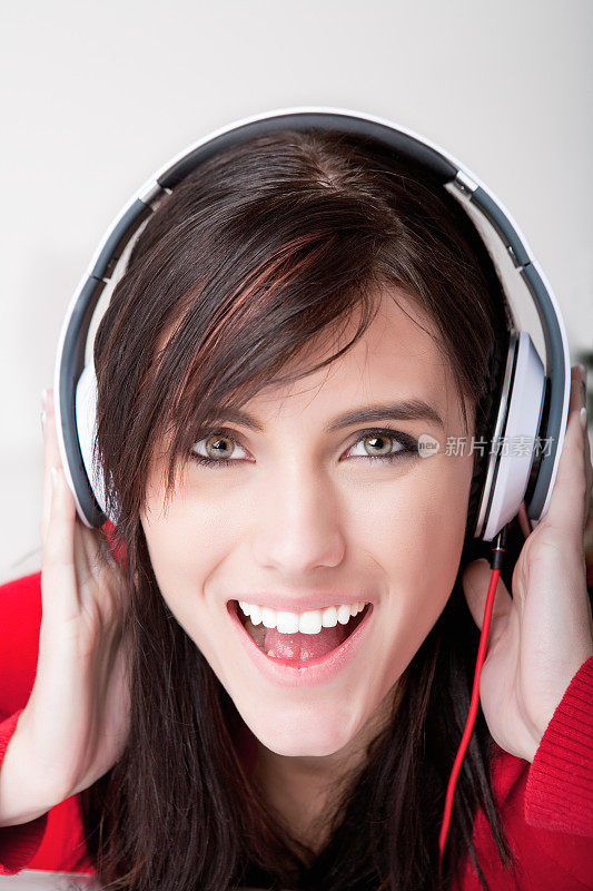 快乐的女人戴着耳机听音乐