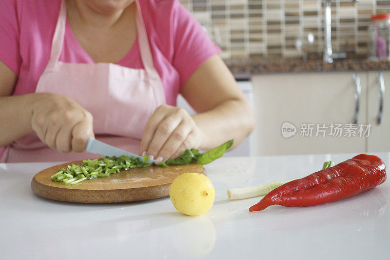 女人在厨房里做健康的食物，蔬菜沙拉