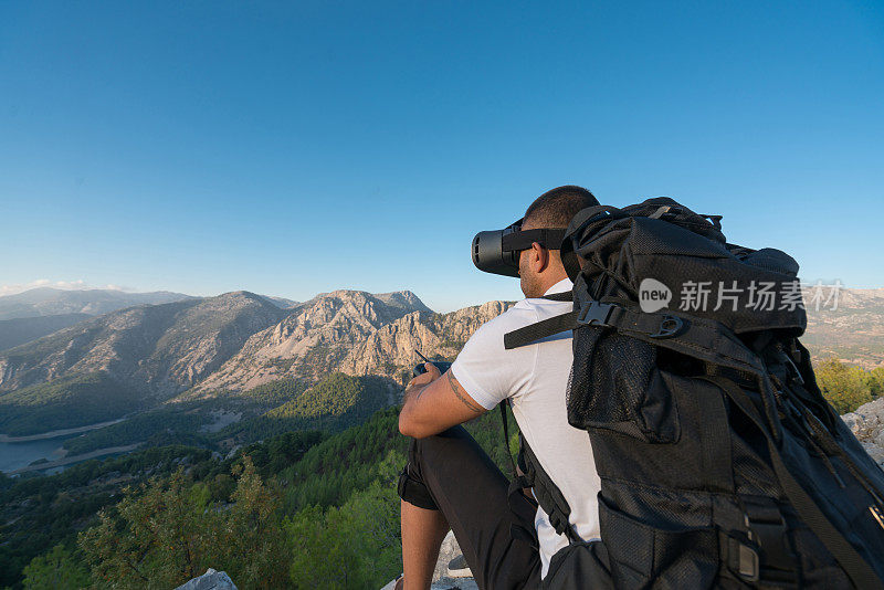 徒步者无人机飞行员使用fpv护目镜在山上飞行