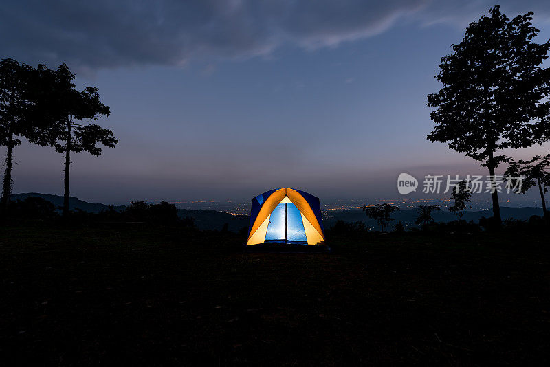 夏季山脊上的黄色帐篷在黄昏时被照亮