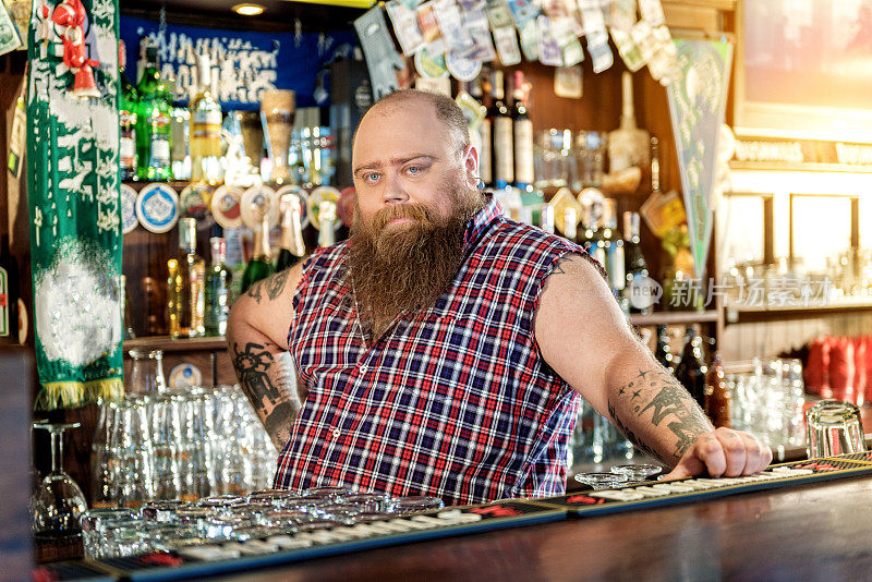 冷静的胖男倚靠在酒吧的工作台上