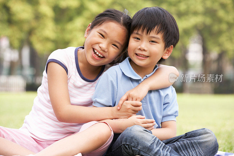中国男孩和女孩一起坐在公园里的肖像