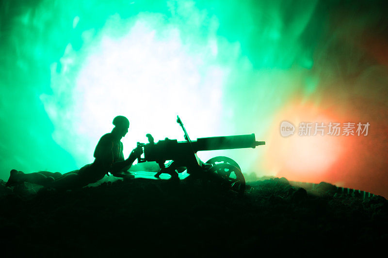 人与机关枪在晚上，火灾爆炸背景或军事剪影战斗场景的战争雾天空的背景，世界大战士兵的剪影在云下的天际线在晚上。