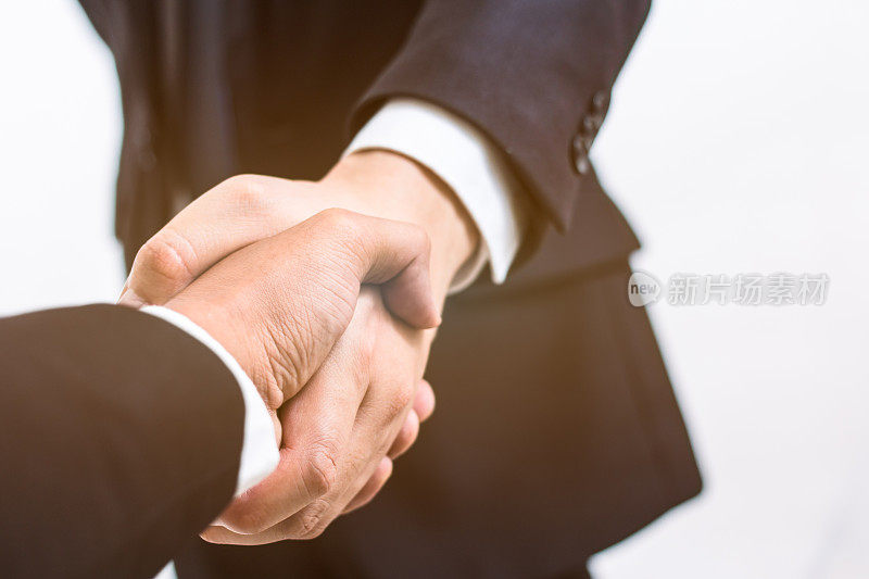 经营理念。握手达成协议的业务合同。成功的商人在成交后握手。年轻的商人在白色背景下的商务会议上握手。