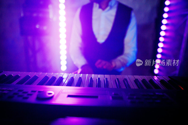 键盘手在舞台上与灯光。