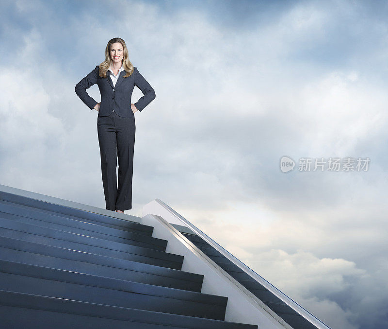 自信的女商人站在楼梯的顶端
